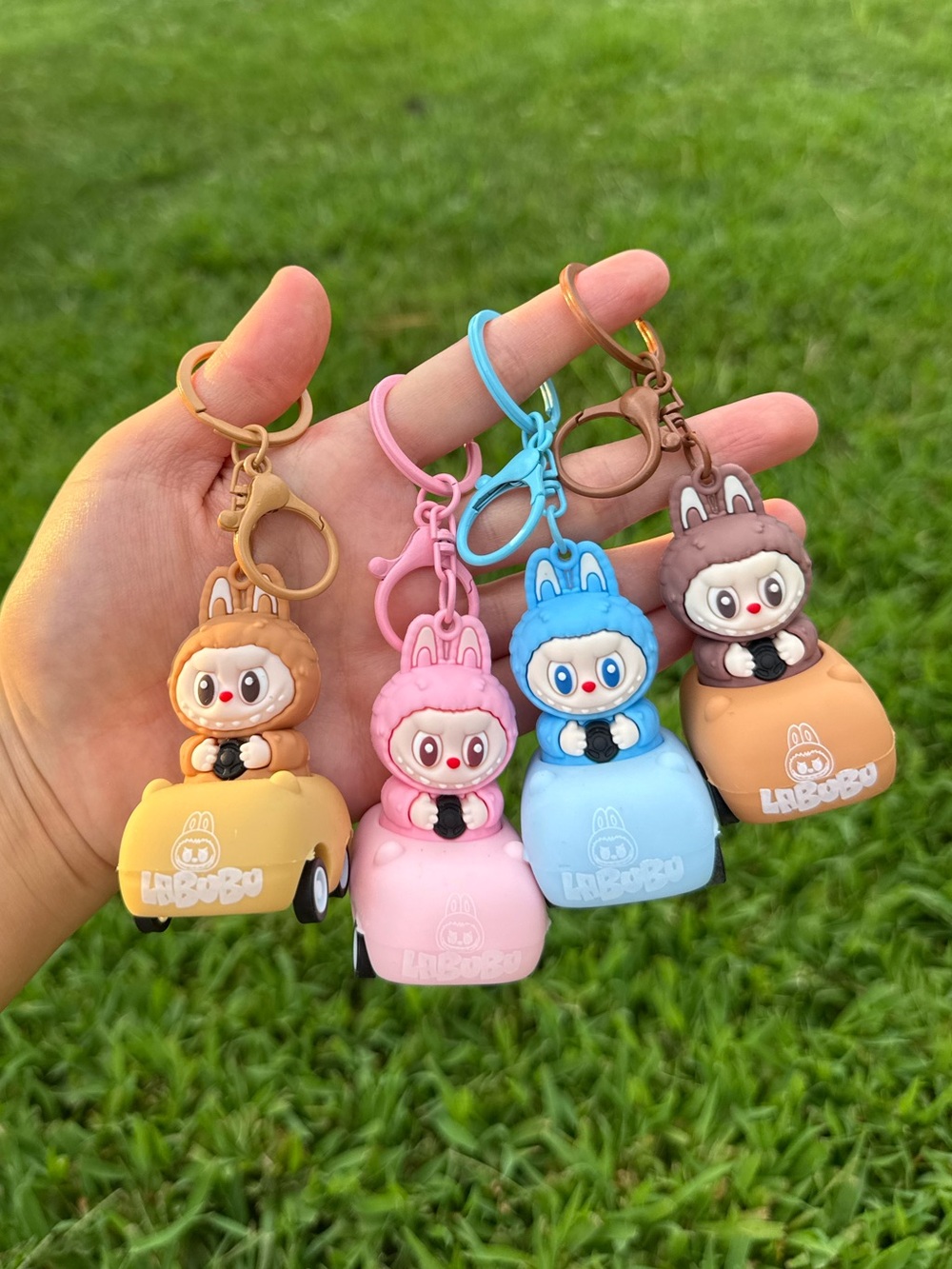 Rolling back toy car keychain with Labubu monster in pink blue yellow brown